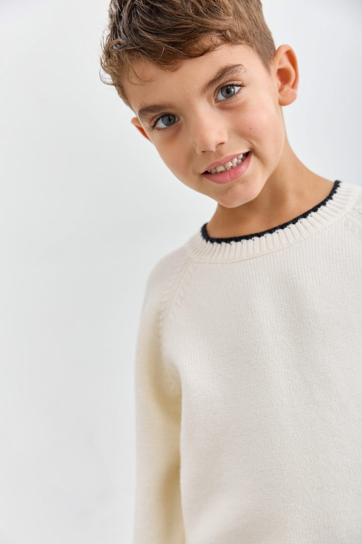 סריג בגזרת אוברסייז בשילוב תיפורים בולטים | קרם