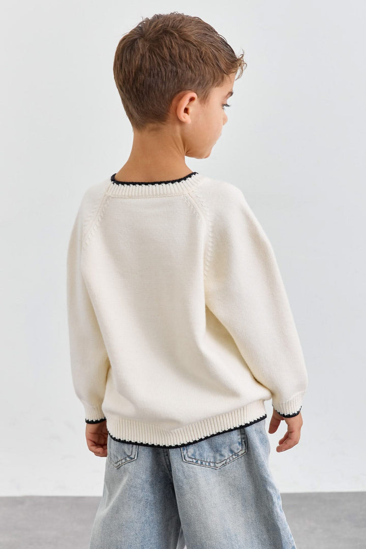 סריג בגזרת אוברסייז בשילוב תיפורים בולטים | קרם